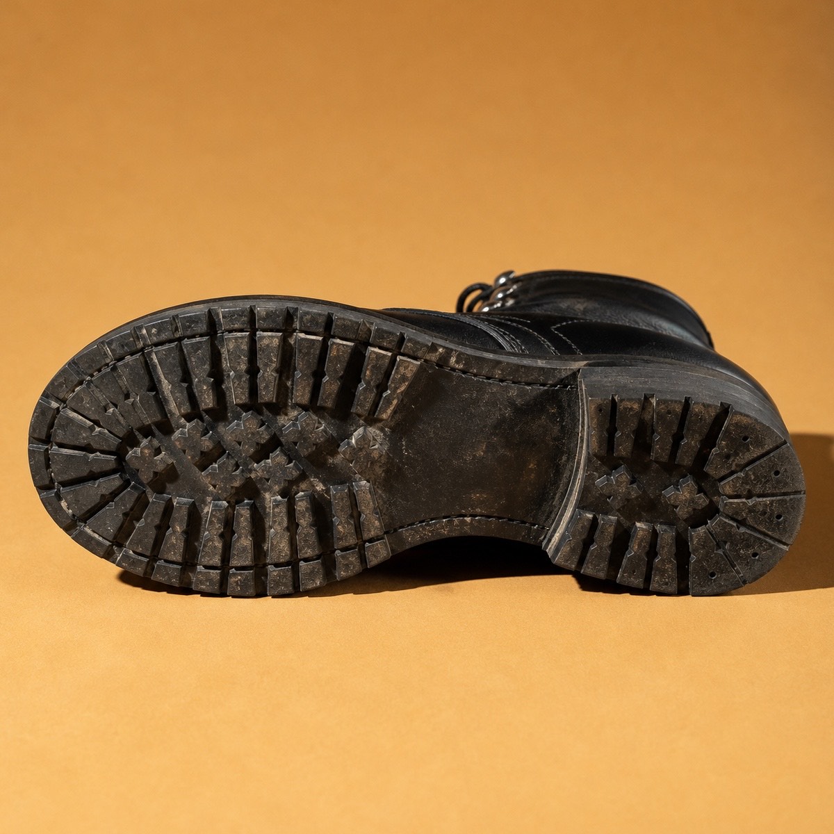 Black leather boot tread in a directed fashion detail.