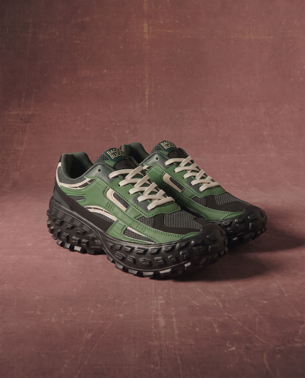 The pair on a warm maroon ground at a three-quarter angle, the tread reading clearly.