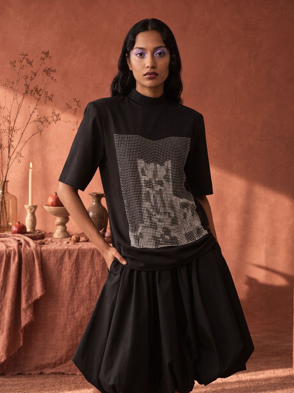 Close frame of the black printed tee, hand on hip.