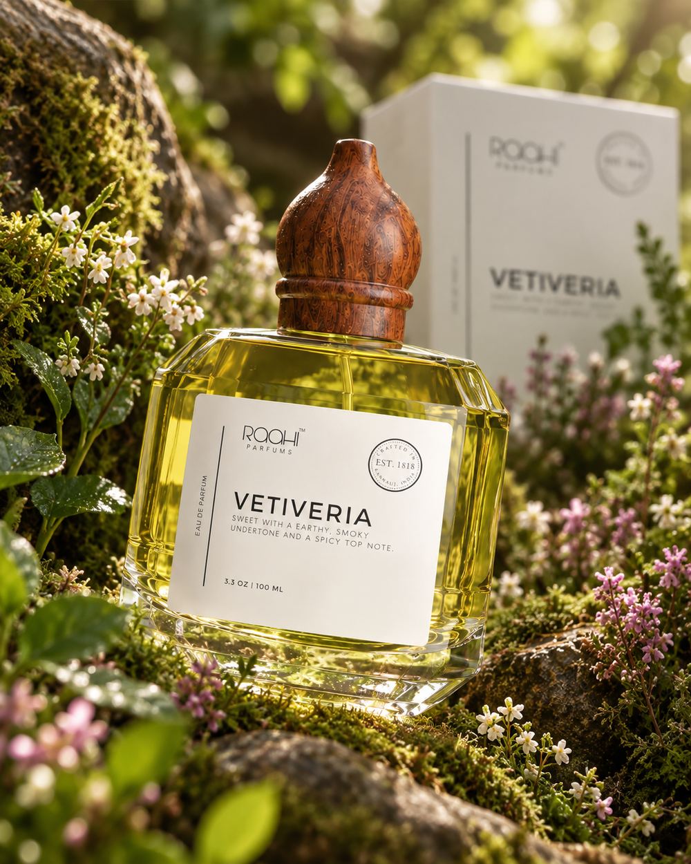 Front view of the vetiver bottle and its carton standing together on wet moss in green filtered light.