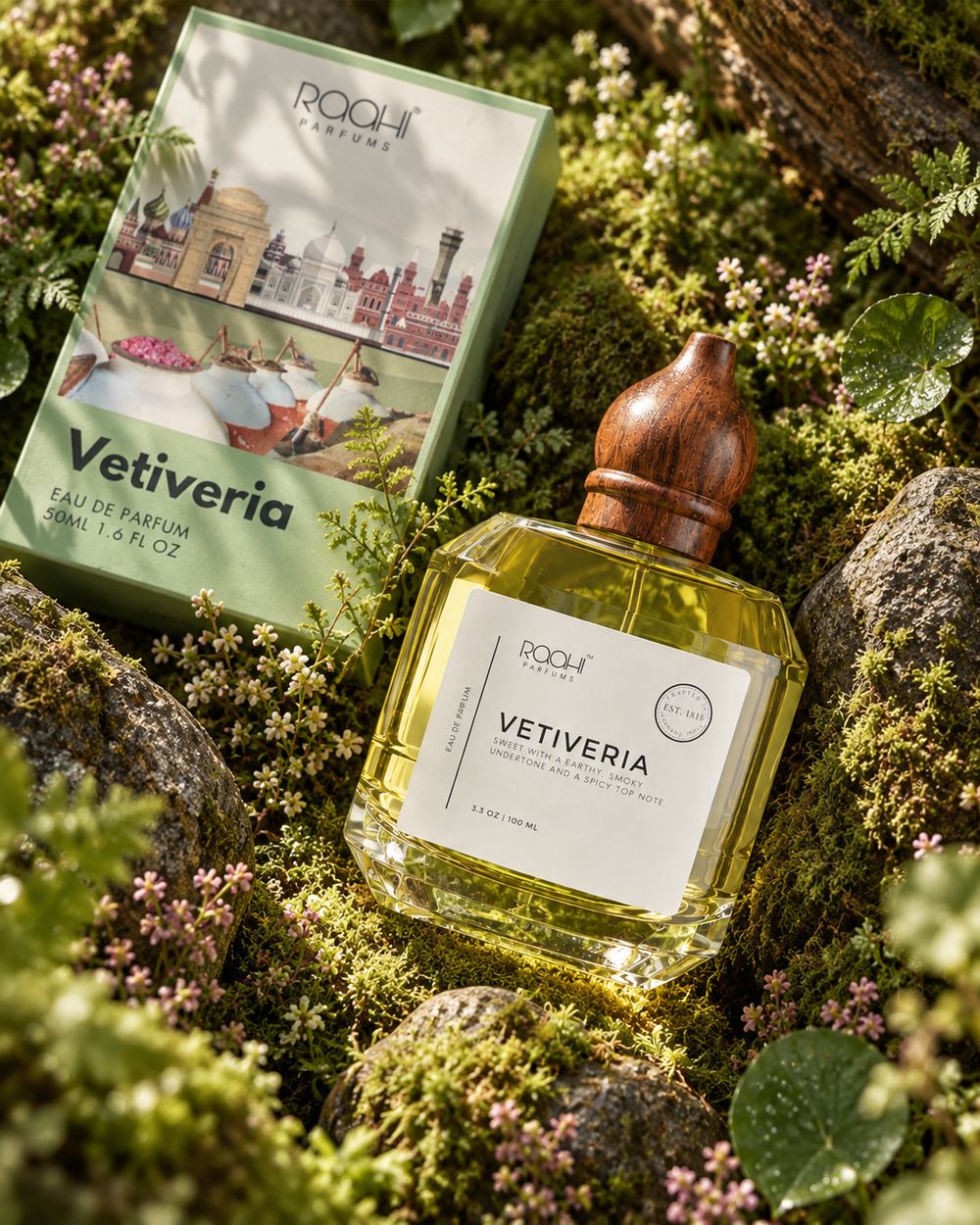 The fragrance with an illustrated presentation carton propped on rocks above a bed of moss and flowering heather.